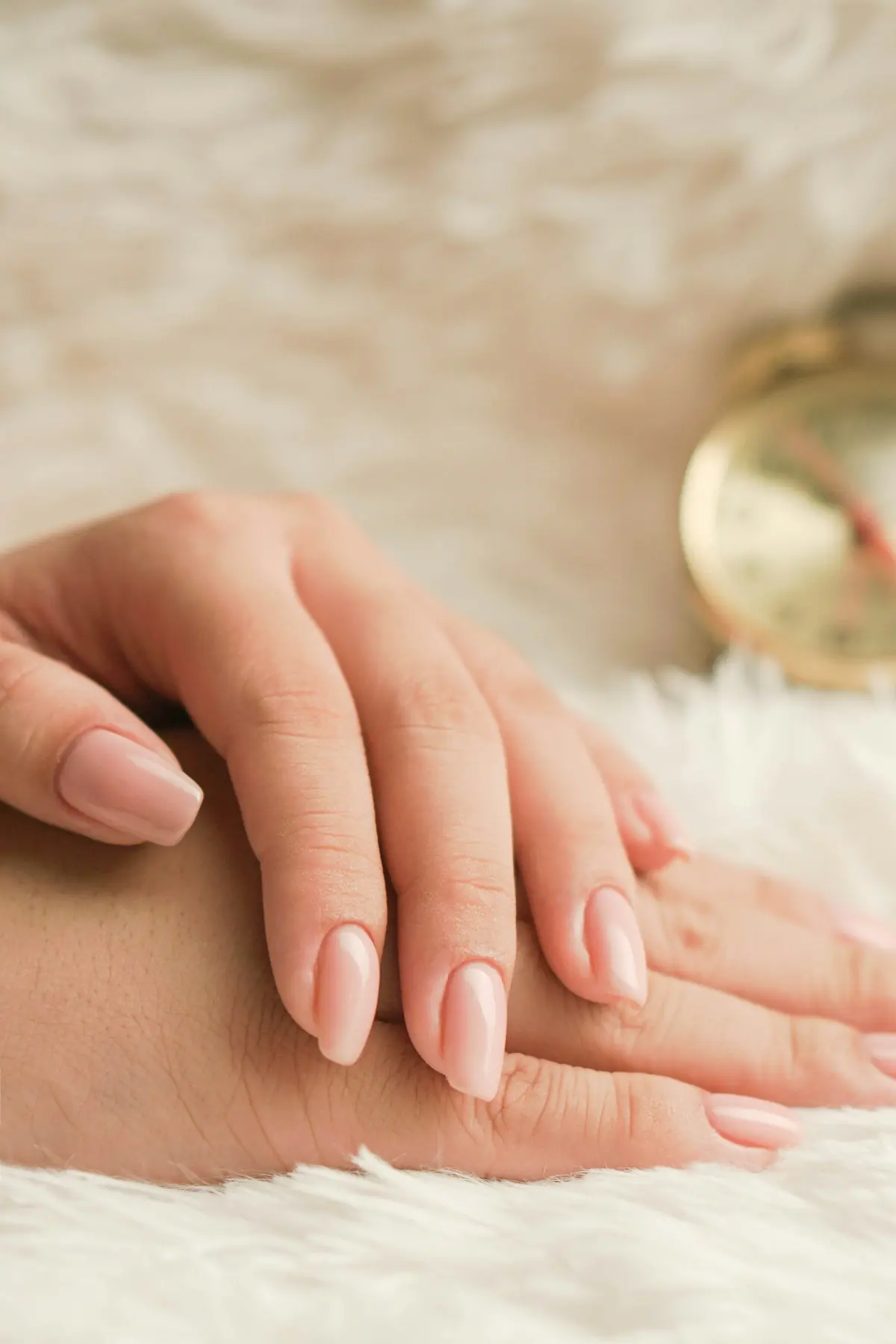Mains aux ongles nude brillants, forme amande naturelle