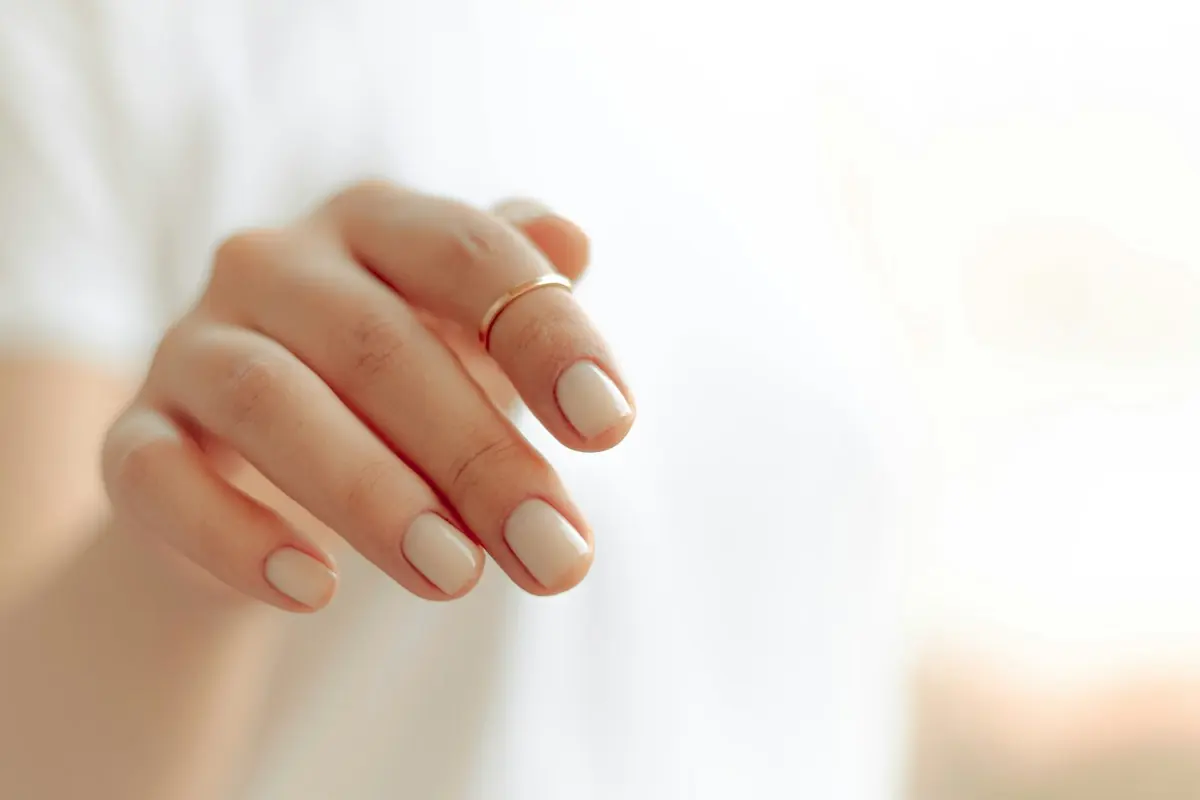 Semi-permanent blanc laiteux, main aux ongles courts et soignés