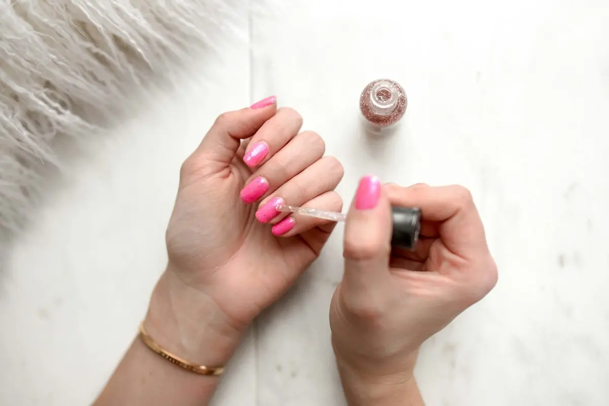 Application d'un vernis rose pailleté